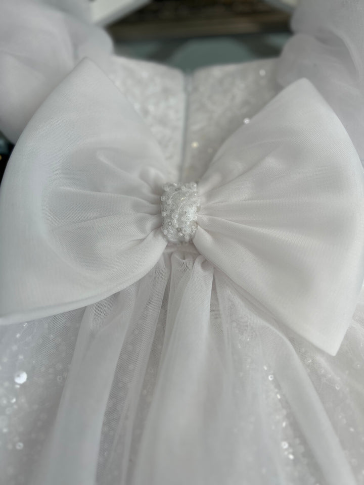 Large fabric bow with glass beads and pearl detailing. Aleena Children’s dress with long bridal train. In white sparkle glass beads and sequins. Perfect for as a christening dress, flower girls dress, baptism outfit, communion dress.