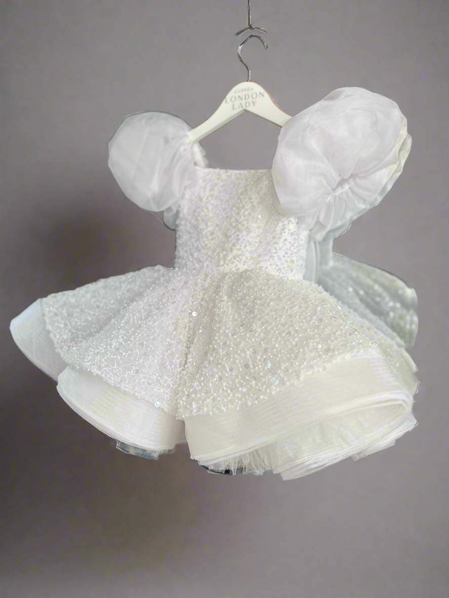 Aleena Children’s dress with long bridal train. In white sparkle glass beads and sequins. Perfect for as a christening dress, flower girls dress, baptism outfit, communion dress.