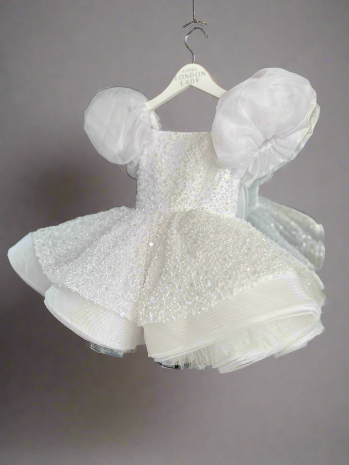 Aleena Children’s dress with long bridal train. In white sparkle glass beads and sequins. Perfect for as a christening dress, flower girls dress, baptism outfit, communion dress.