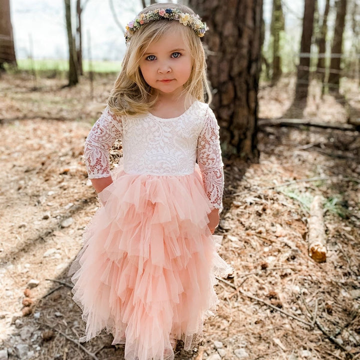 Little Flower Girl wearing a white and pink ruffle dress.