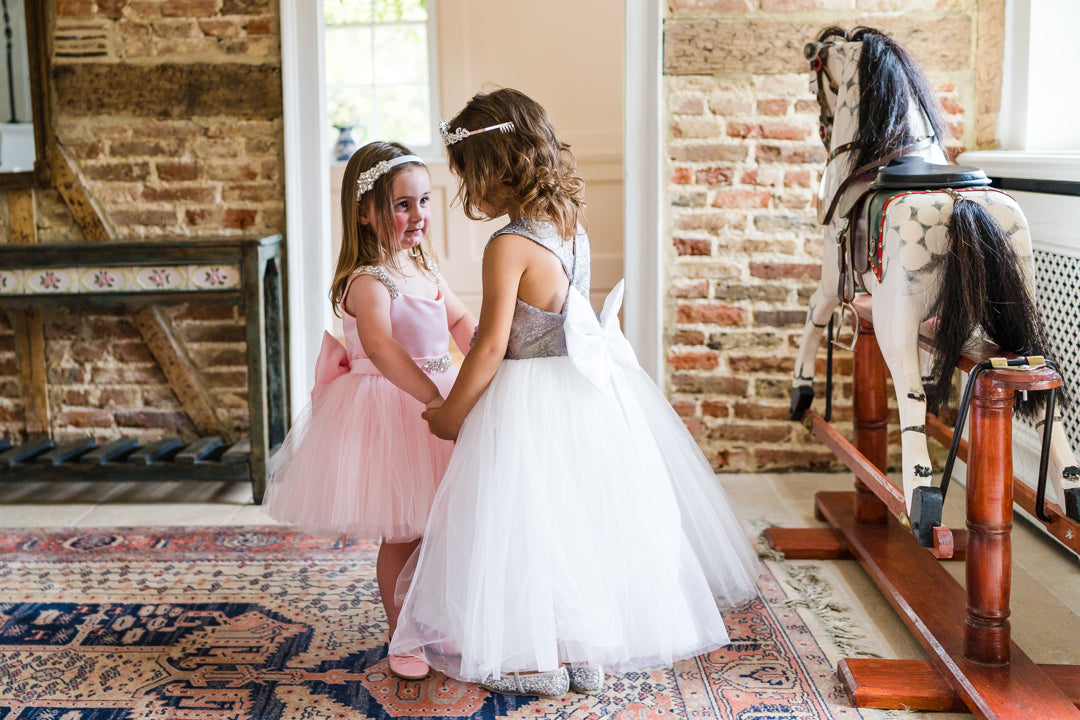 The Sweetpea Tutu dress in Pink and the City Shimmer White and Silver Childrens designer dresses. beautiful and hand made in England. The City Shimmer childrens dress with Silver Sequin Bodice and adjustable straps. A line white tulle skirt and oversized white satin bow and tails at the back. This dress is perfect for Flower girls, little bridesmaids, pageants, wedding guest, birthday parties or any special occasion. Size 1 Years to 10 years