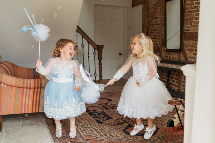 Baby Blue Bluebell Embellished Lace dress has been handmade to the highest standards for your discerning little lady. A sweet round neck with standout pearl button to close at the back and embellished tulle sleeves are the standout of this elegant blue design, which is completed with a wonderful oversized satin bow on the back. The tulle with lace trim makes this dress totally timeless. Lots of volume in the skirt. Also available in white and pink 